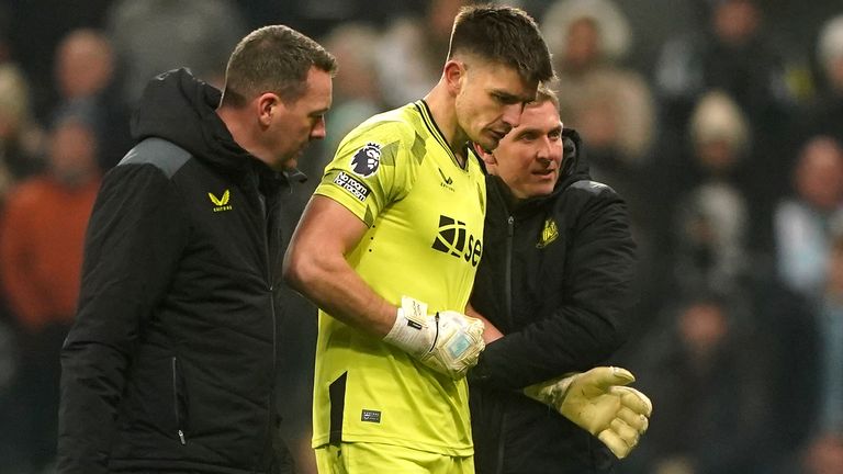 Nick Pope is helped off the pitch by medical staff
